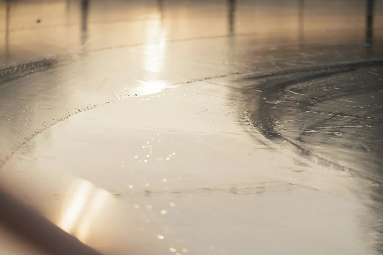 Close-up of a glossy coated concrete floor catching low sunlight